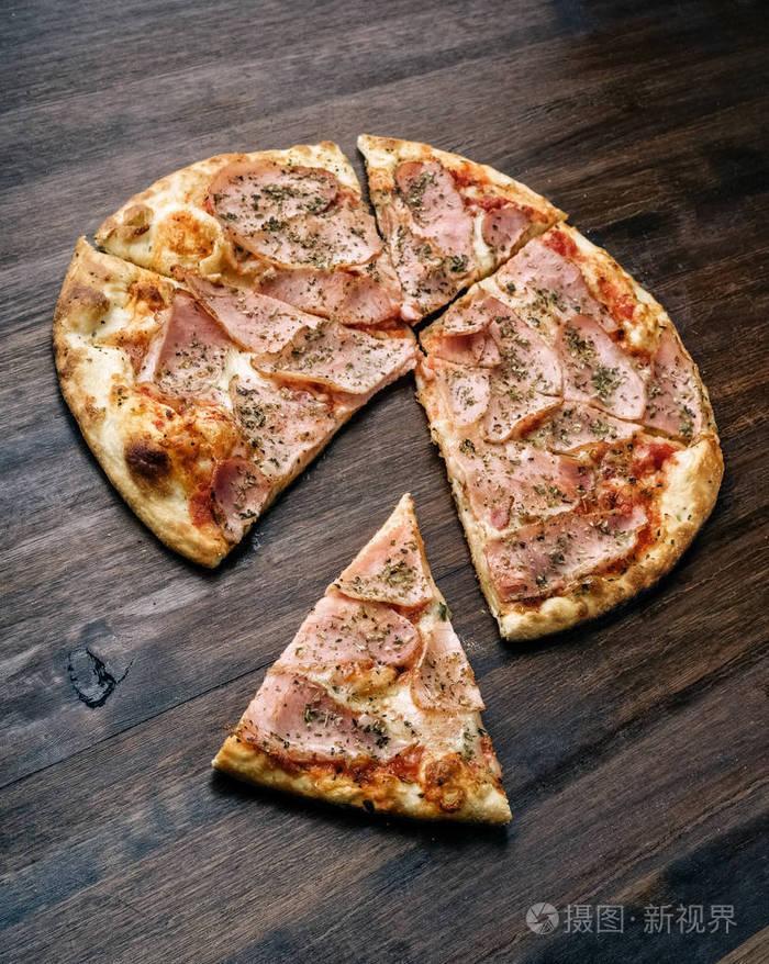 一块披萨火腿和奶酪在木桌上