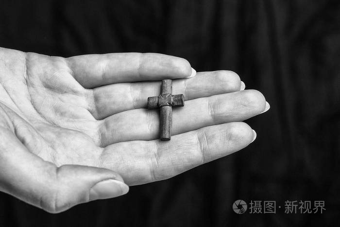 在黑暗的背景交叉在女性手中黑白照片