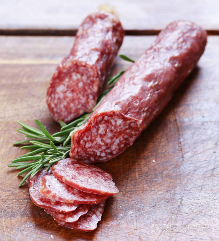 萨拉米香肠配迷迭香在木板上