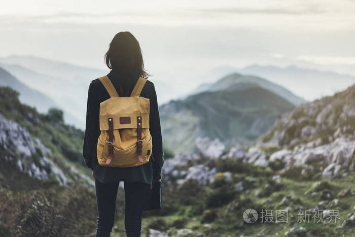 享受夕阳的明亮背包的女孩