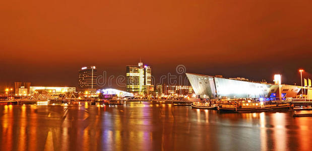 阿姆斯特丹晚上航道上美丽的船只和现代建筑景观