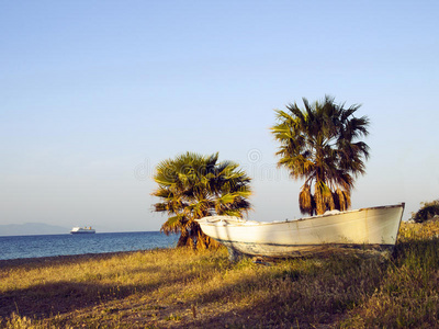 科斯希腊海滩上的船和两只手掌
