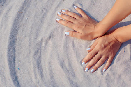 女性的手在沙子里玩耍