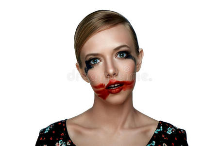 美丽的女孩在张开的嘴上涂上红色的口红。