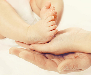特写照片，脚在婴儿手中，母亲和父亲