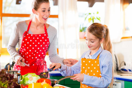 母亲在家教女儿做饭