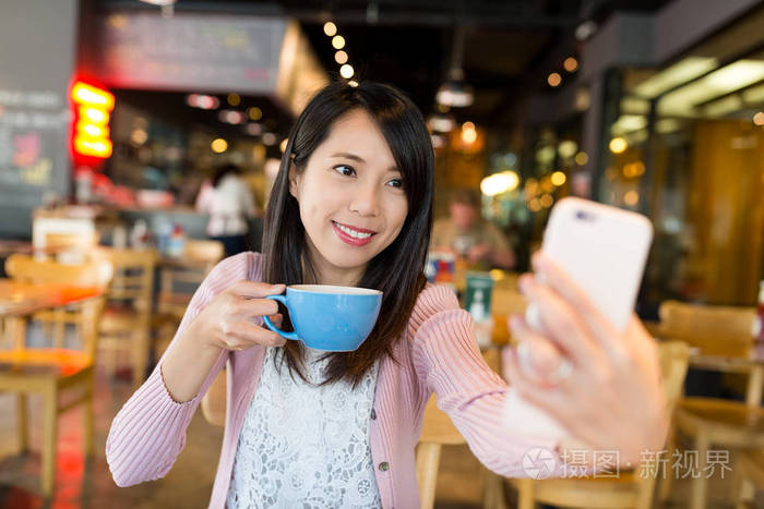 女人采取自拍照与她的饮料