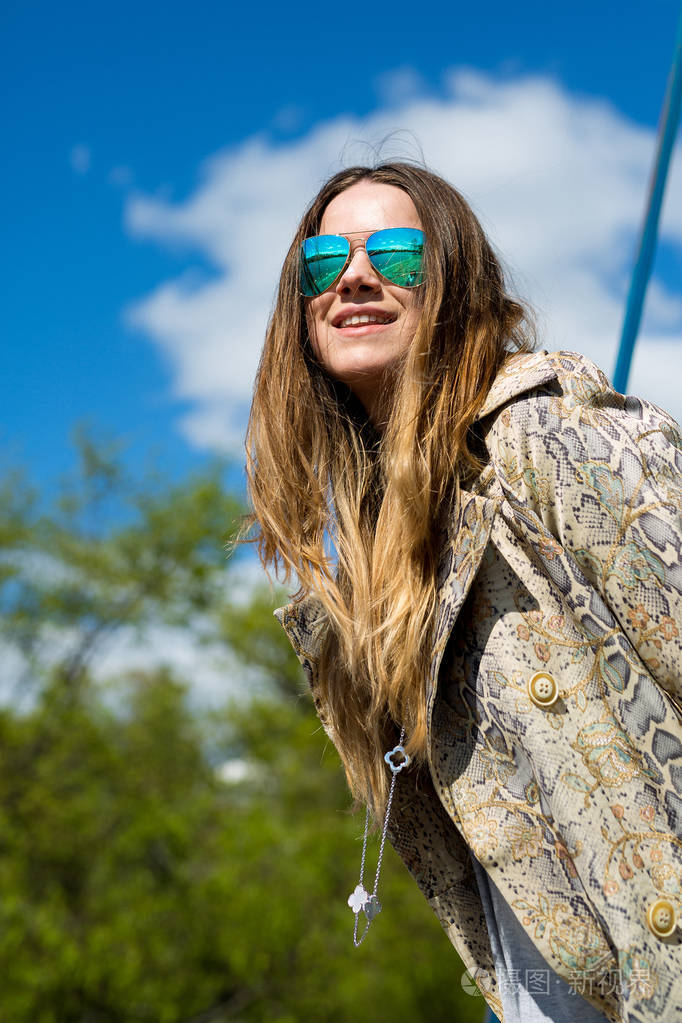 应用了美丽年轻的金发美女,在春天,温暖的筛选器在户外享受阳光,风在