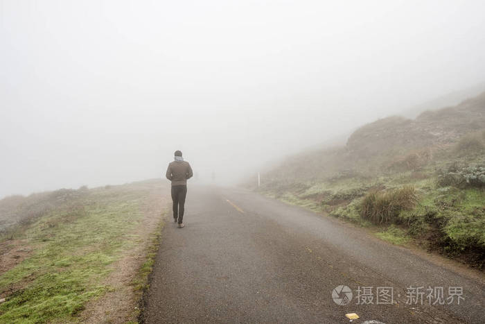 步行穿过雾的男人