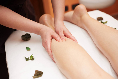 详细的手按摩人体小腿肌肉治疗师对女性腿施加压力