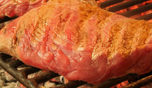 在壁炉上煮熟的大牛肉牛排照片