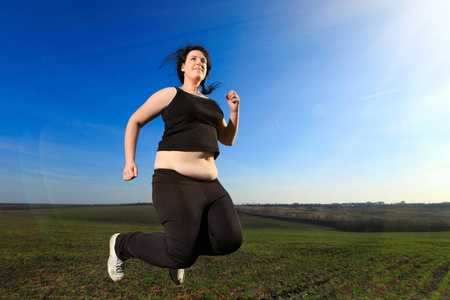 在农村,在草地上跳跃的胖女人照片