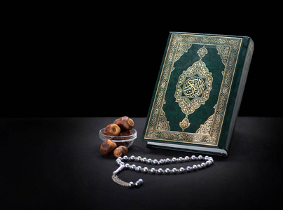 圣书古兰经 》 与念珠和日期照片