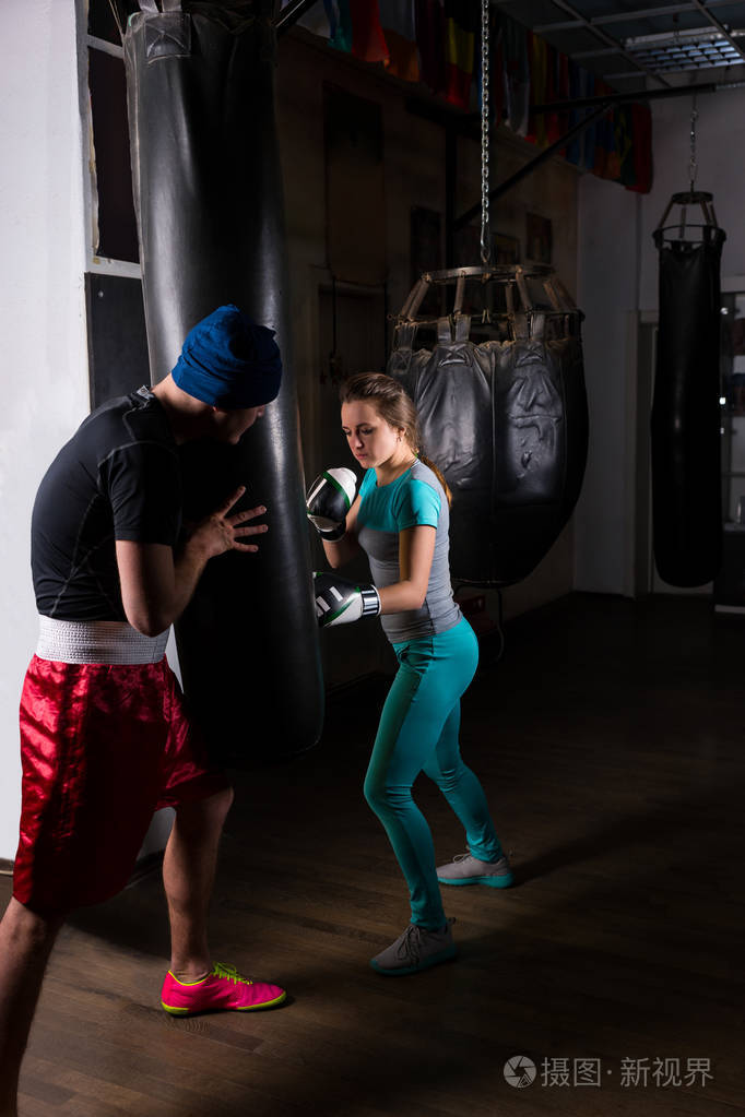 女性运动拳击手在拳击训练与她的教练
