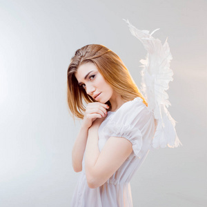 在白色翅膀的天使形象年轻 精彩的金发女郎照片