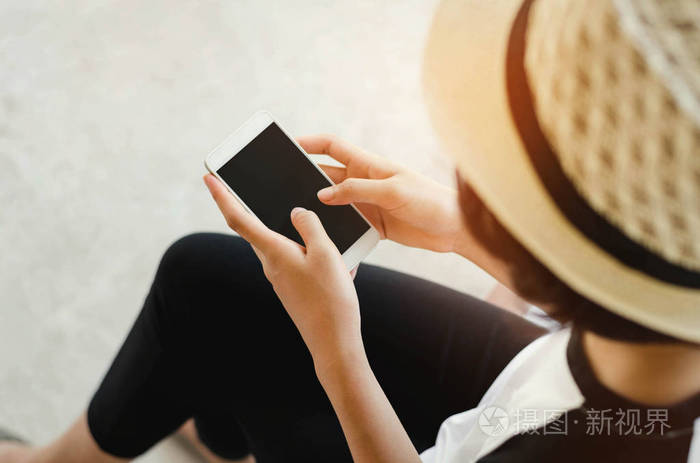 年轻女子捧着一个黑色屏幕的智能手机，玩 soc