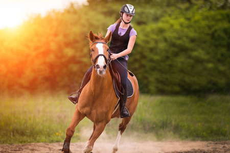 年轻漂亮的女孩,骑着马与背光遗留在 s照片