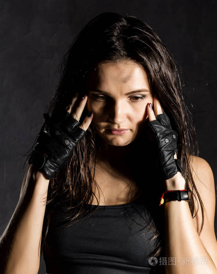 美丽性感的女拳击手或mma在深色背景上戴着黑色手套