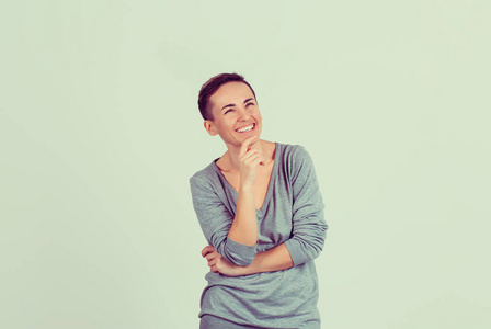 特写肖像自信微笑女人白日梦手上的下巴考虑隔离光绿墙背景.