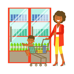 年轻的女人推着推一些货物和孩子坐在购物车超市购物车.