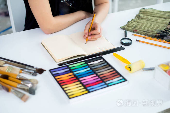 特写镜头角度视图的女画家在写生使用铅笔绘图草案艺术家素描艺术工作