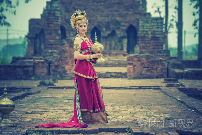 古代美丽的亚洲女人穿着传统的泰国服装站在古代纪念碑前泰国风格.