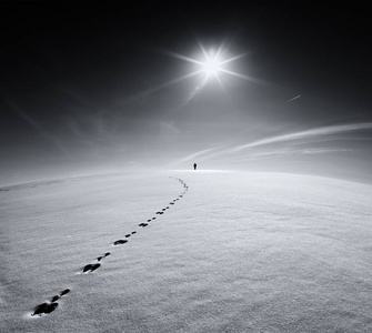 一个男人在冬天空字段的道路上照片