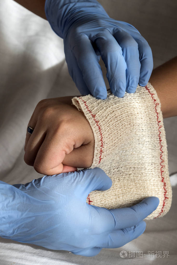 特写的护士绑绷带上病人的手照片-正版商用图片1ryexu-摄图新视界