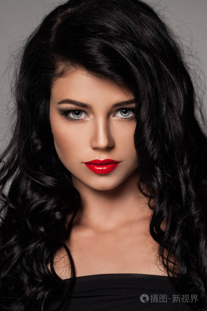 有卷发的性感黑发女人的肖像.美丽的女性