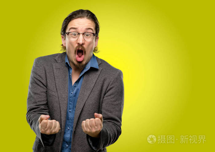 英俊的年轻人高兴而兴奋地庆祝胜利表达了巨大的成功动力和积极的情绪