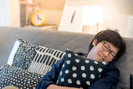 睡在客厅沙发上的亚洲青年男子图片