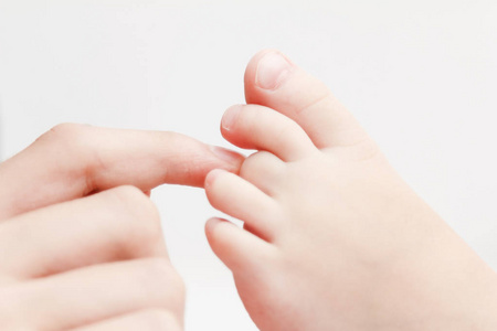 婴儿脚在母亲的手.妈妈和她的孩子.幸福的家庭观念.