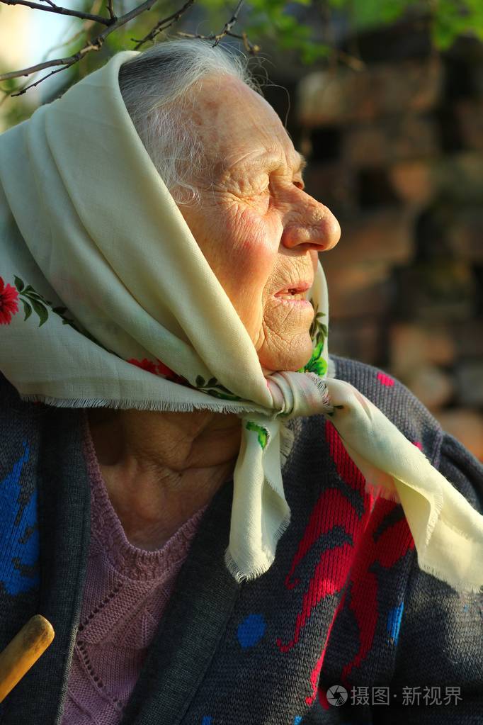 一位90岁以上的老妇人欣赏日落的侧景