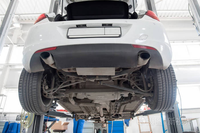 汽车在车轮对齐升降机在汽车服务. 电梯处升起的汽车底盘的诊断.