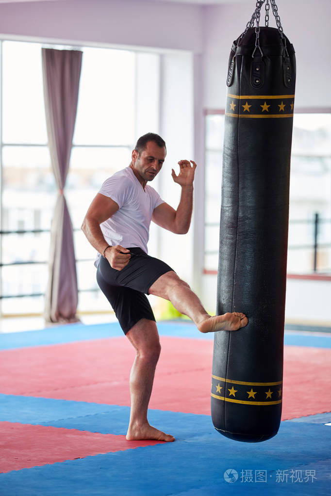 在健身房里用沉重的袋子训练拳击手