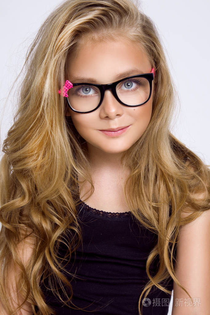 可爱的金发小女孩戴着白色背景的眼镜在工作室里