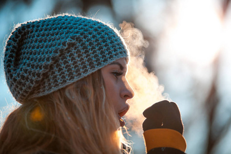在寒冷的冬天,女人用手呼吸,让她们保持温暖照片