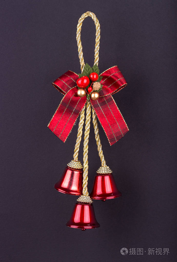 圣诞装饰品黑色背景上的三个红铃