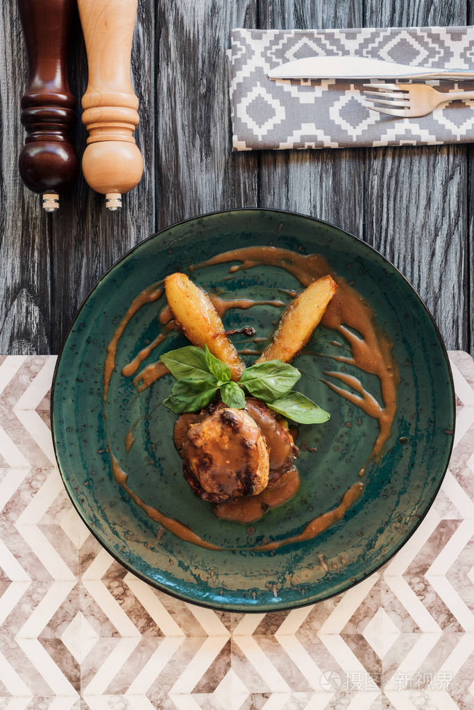 美味的烤牛排,盘子上有罗勒叶