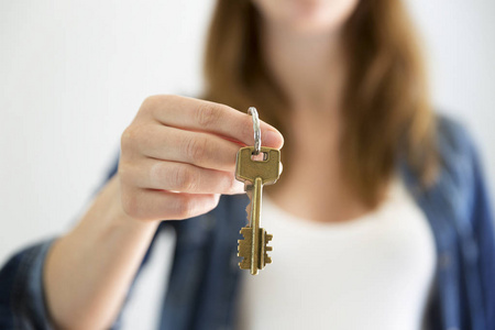 女人拿着房子钥匙.房地产租金或购买概念照片