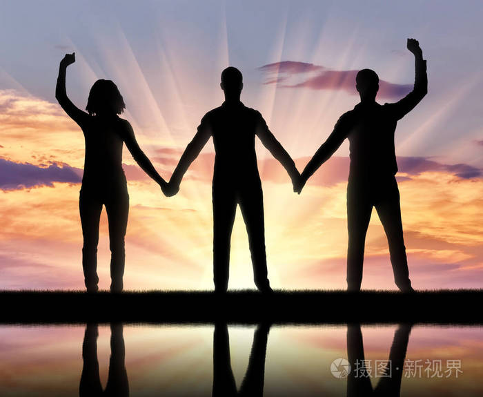 剪影的一群快乐的人,三个人牵着手. 互助的概念