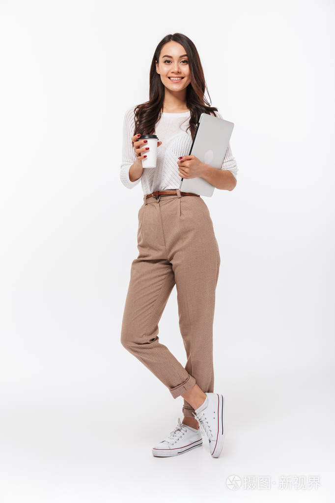 一位带着笔记本电脑和咖啡的微笑的亚洲女商人在白色背景下孤立地站着