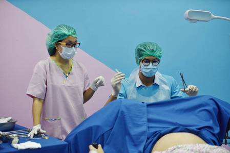 去医院医生和护士正在进行盆腔手术.去医院生孩子的那个女人.照片