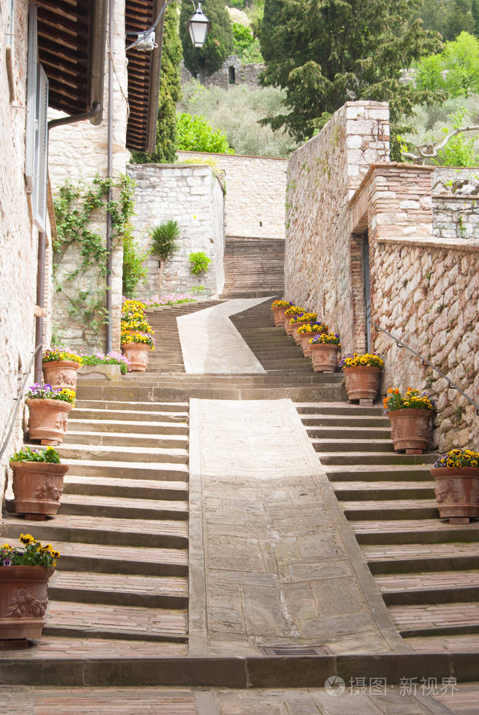 在古比奥市的一条小路上,沿着一条着花盆的上坡台阶