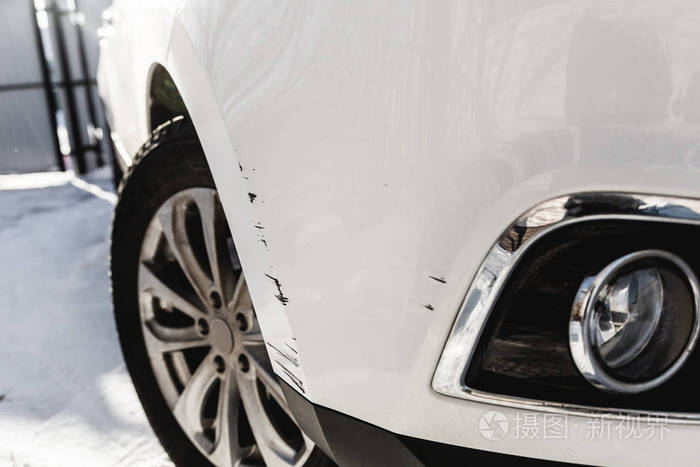 白色汽车保险杠上的黑色划痕和擦伤