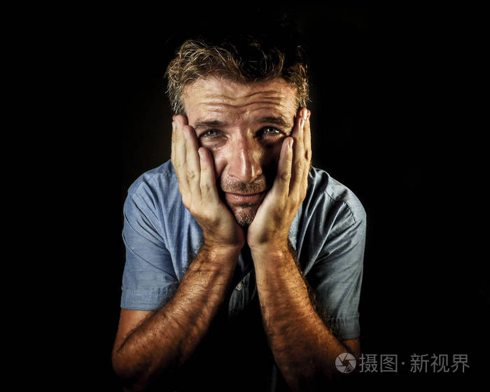 富有吸引力的悲伤和沮丧的人的戏剧性肖像,双手放在脸上,哭泣,绝望