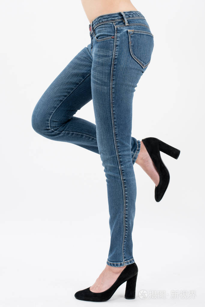 亚洲妇女摆姿势,抬起她的腿在牛仔裤前面的观点孤立在白色背景.