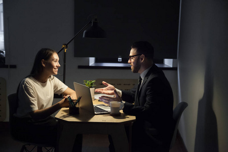 通宵加班说说同事在办公室加班讨论业务计划照片