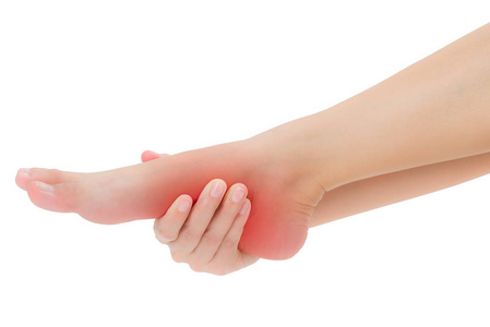 女人的手拿着美丽的健康的脚,在疼痛区域按摩,红色突出孤立在白色背景