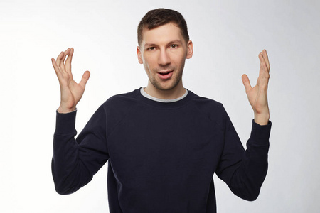 室内工作室拍摄的惊讶的男性工人显示大小的鱼,他捕获.